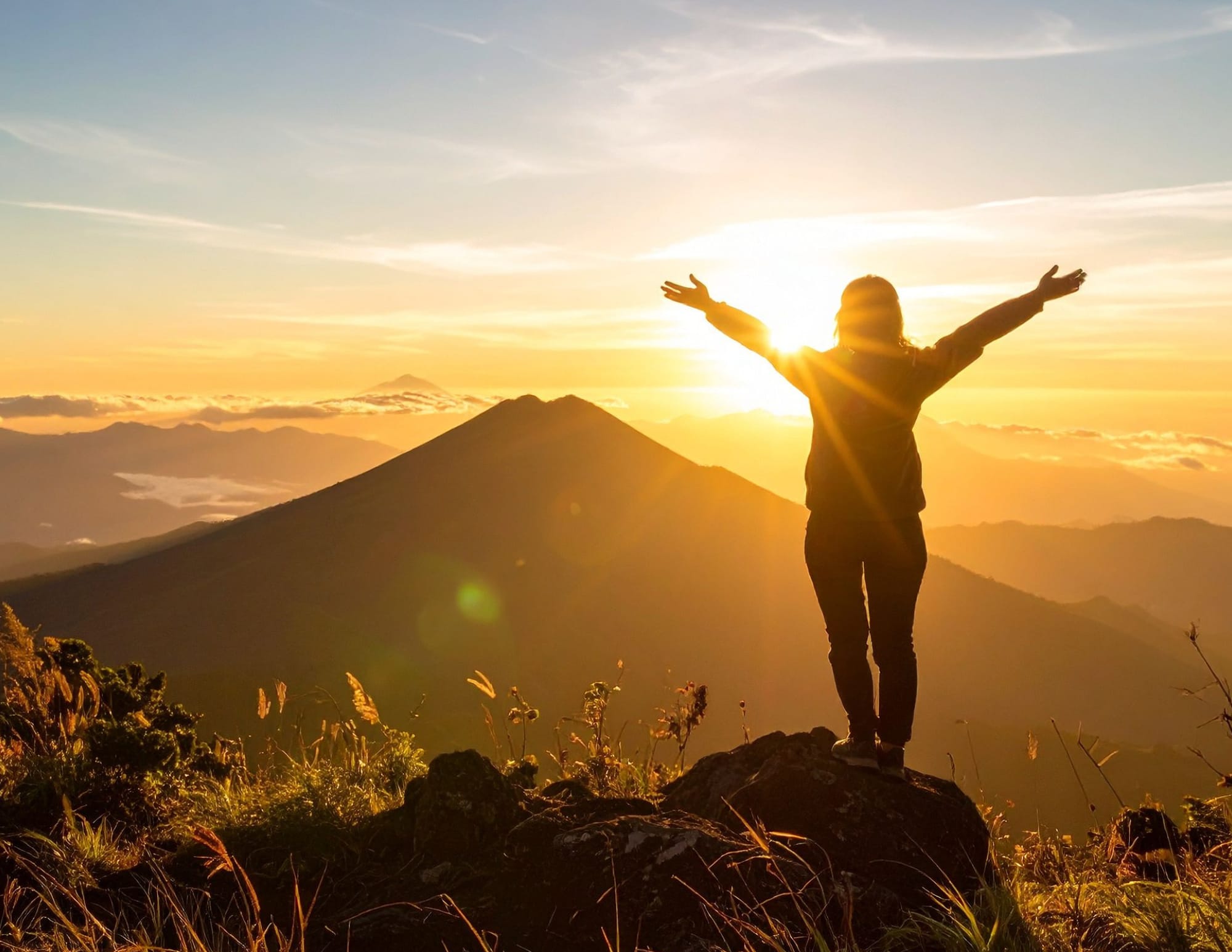 Personne face au soleil sur une montagne réveillant son énergie