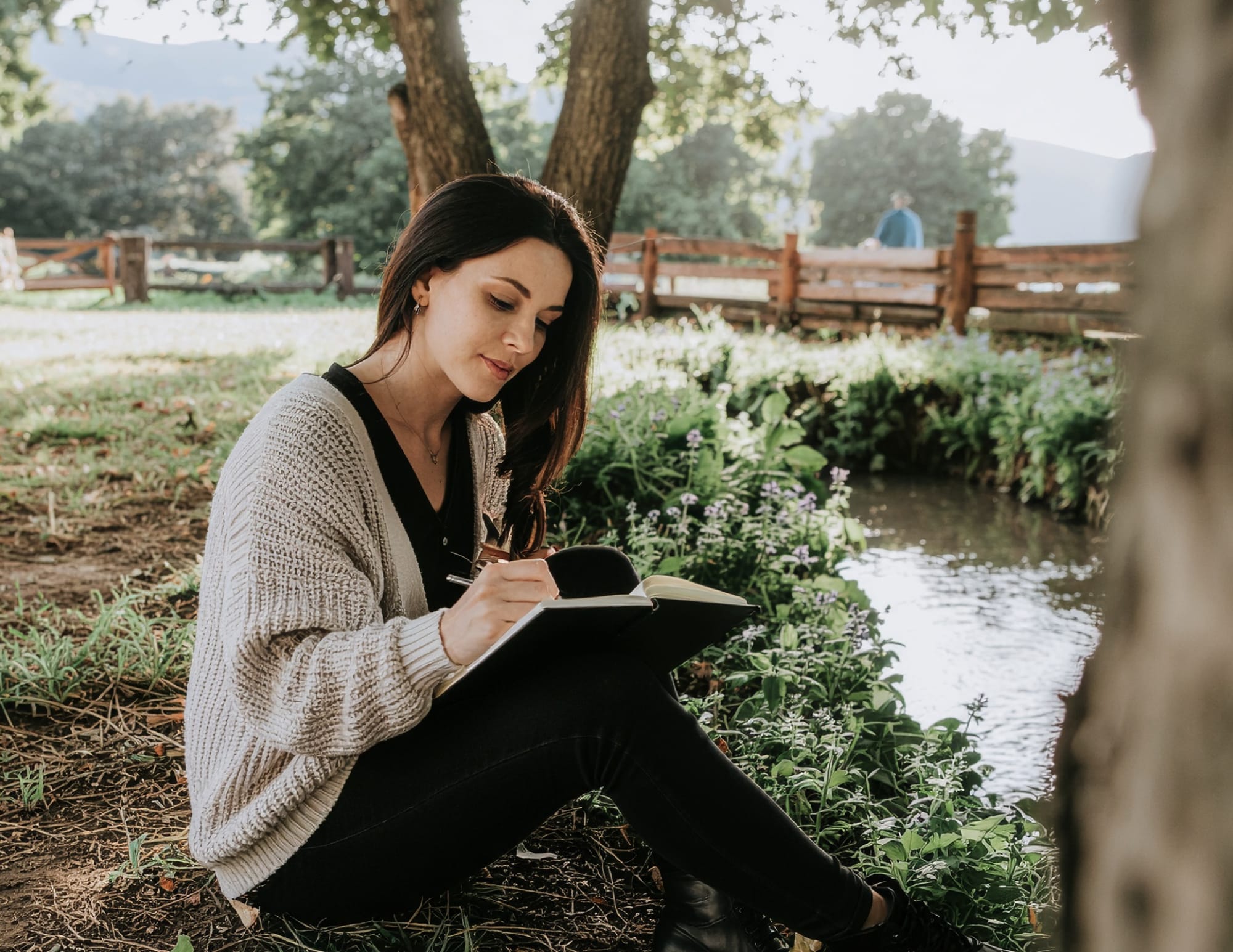 Femme écrivant sereinement sur le Reiki dans un parc
