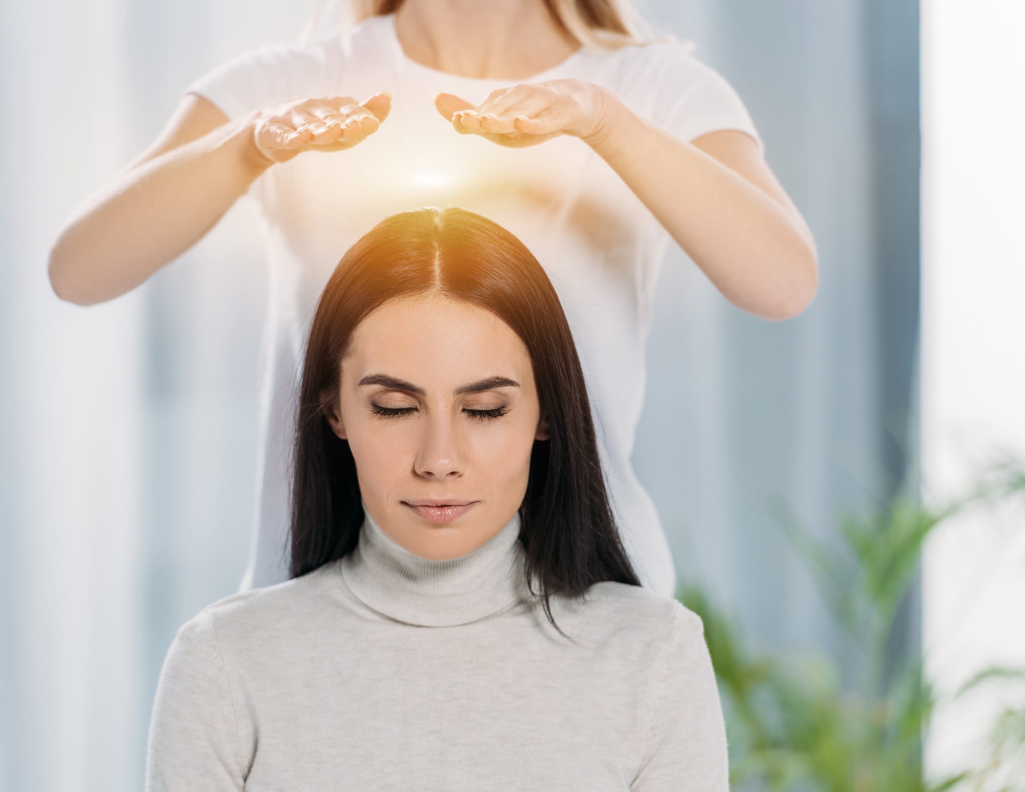 Praticien Reiki posant les mains au-dessus de la tête d'une personne pour un soin mental et émotionnel