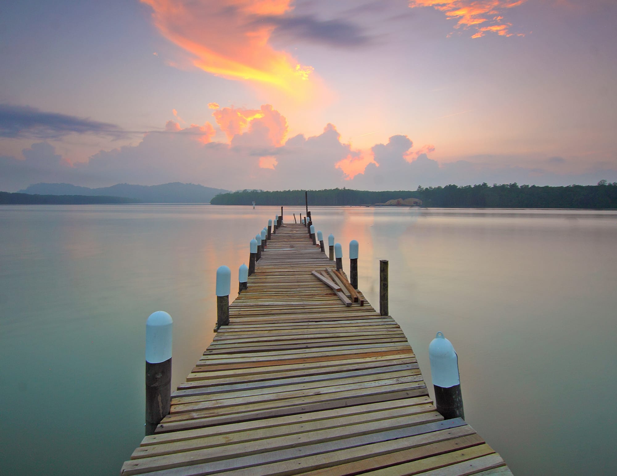 Pont en bois au-dessus d'un lac représentant le passage des niveaux et l'initiation Reiki