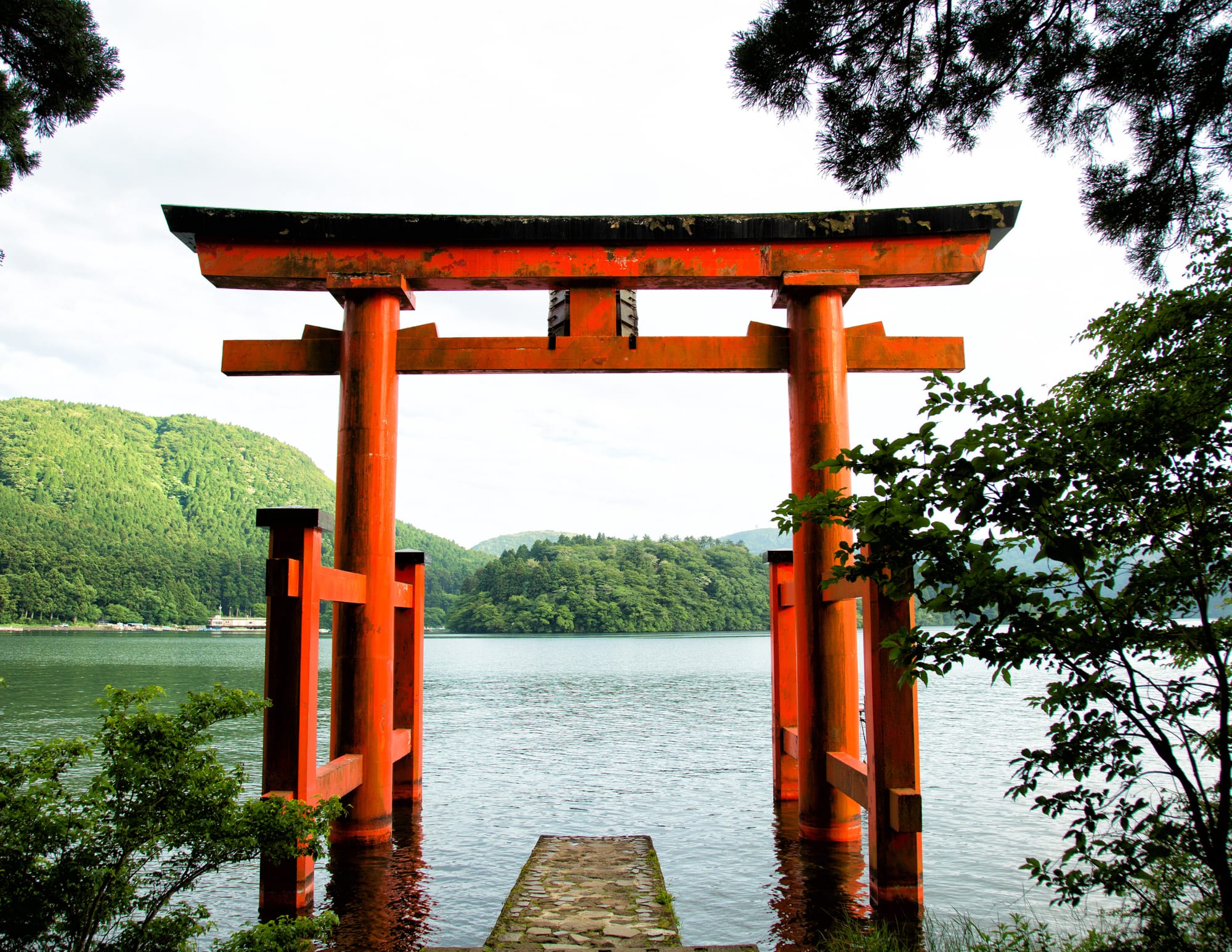 Porte torii japonaise devant un lac paisible symbolisant la tradition du kotodama
